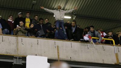 Arsenal supporters celebrate and remove banners at White Hart Lane on Wednesday night after a League Cup win over Tottenham. Frank Augstein / AP