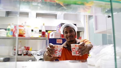 Anas serves tea to customers at King Karak. Pawan Singh / The National