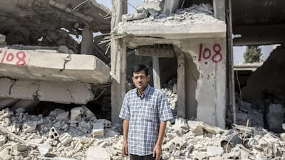 Abdullah Kurdi, whose family drowned off Turkey, stands in front of his neighbour’s house in Kobani, Syria, yesterday. Yasin Akgul / AFP