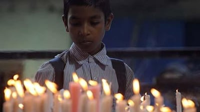 A schoolboy lights candles in front of a picture of slain Rabbi Gavriel Holtzberg in Mumbai for the second anniversary of the November 26, 2008 Mumbai attacks.