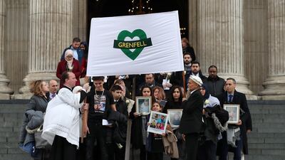 Mourners hold up photographs of victims as they leave the Grenfell Tower National Memorial service at St Paul's cathedral. Daniel Leavl-Olivas-Pool Getty Images