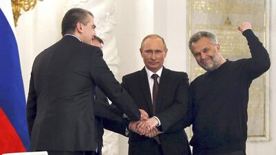 The Russian president Vladimir Putin, second from right, Crimea’s prime minister Sergei Aksyonov, left, Sevastopol mayor Alexei Chaliy, right, and the Crimean parliamentary speaker, Vladimir Konstantinov, shake hands at the Kremlin after the signing of a treaty to make Crimea a part of Russia. Sergei Ilnitsky / Reuters / March 18, 2014