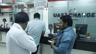 Customers wait at a Dubai exchange. The Government has mooted taxing remittances (Jeffrey E Biteng / The National)