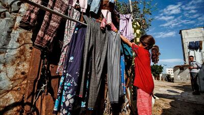 A Palestinian girl hangs clothes out to dry on a line outside her home in Gaza City. AFP
