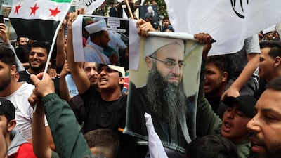 Protesters shout slogans as they carry pictures of Lebanese cleric Ahmad Al Assir and Syrian flags during a protest in Beirut. EPA