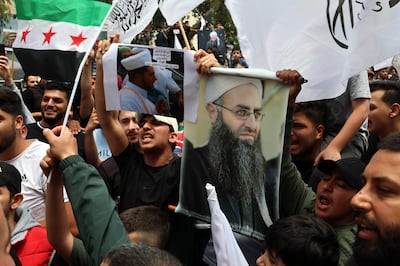 Protesters shout slogans as they carry pictures of Lebanese cleric Ahmad Al Assir and Syrian flags during a protest in Beirut. EPA
