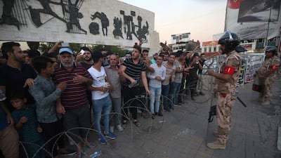 Members of the Iraqi security forces stand guard as protesters in the capital's Tahrir Square demonstrate against unemployment. AFP
