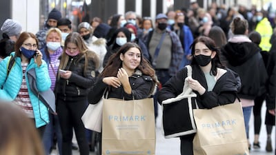 People carry shopping bags as others queue to enter a store on Oxford Street in London. April's inflation jump is mainly driven by a rise in domestic energy prices along with clothing and footwear and the cost of petrol. AP