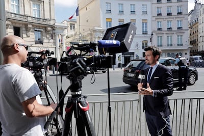 A journalist gives an update outside the Elysee Palace in Paris, as French President Emmanuel Macron seeks to find a new prime minister. AFP