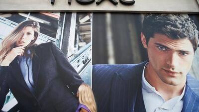 A woman walks past e a branch of clothing retailer Next in London, Britain. The company trades from about 500 physical stores in the UK, as well as online, with a heavy international presence, including 14 UAE branches franchised by the Alshaya Group. Reuters