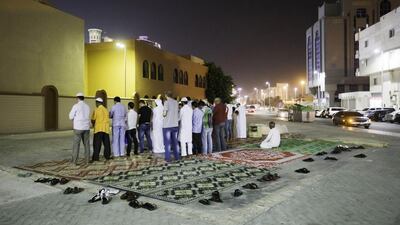 Residents in Al Wahda, in the capital, perform isha prayers at the site of Mosque 299, which was knocked down two years ago. Jaime Puebla / The National