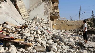 A young Syrian stands looking at the rubble of a collapsed building as rescuers look for victims following an air strike on the rebel-held neighbourhood of Sakhur in Aleppo city on July 19, 2016. Thaer Mohammed/AFP