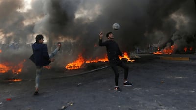 Protesters play football next to burning tyres during ongoing anti-government protests in Basra, Iraq. Reuters
