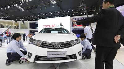 Staff members place a new Toyota Corolla car for display during Auto China 2014 in Beijing, on April 20. Jason Lee / Reuters