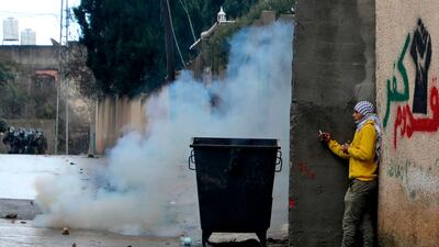 A Palestinian man takes cover during clashes with Israeli troops and Palestinian protesters in the village of Kfar Qaddum near the Jewish settlement of Qadumim (Kedumim) in the occupied West Bank. AFP