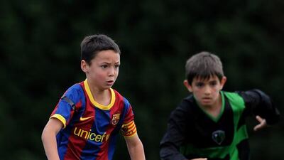 Fifa have handed FC Barcelona a transfer ban for the next two transfer windows for breaching regulations on the international transfer and registration of minors. Pictured in a file photo, eight-year-old Barcelona youth player Arnau Martinez runs for the ball during his match against Llongueras on one of the pitches at the Joan Camper training ground on May 15, 2011 in Barcelona, Spain. Jasper Juinen / Getty Images