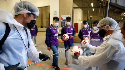 A worker disinfects a ball before the start of a Mexican tournament football match between Guadalajara and Atlas in Guadalajara, Jalisco state, Mexico. AFP