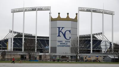 A woman and her dog walk past Kauffman Stadium, home of the Kansas City Royals baseball team, on March 25, 2020, in Kansas City, Missouri. AP Photo