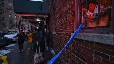 Neighbours watch firefighters at work in the Bronx. AFP