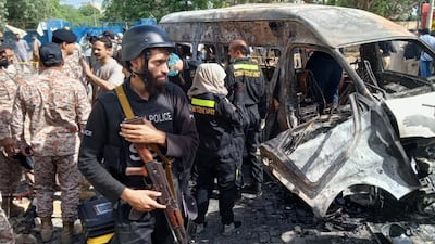 Pakistani security officials inspect the scene of an explosion in Karachi, Pakistan, 26 April 2022. At least Four people were killed including Chinese nationals when a vehicle exploded near Karachi University. EPA / SHAHZAIB AKBER