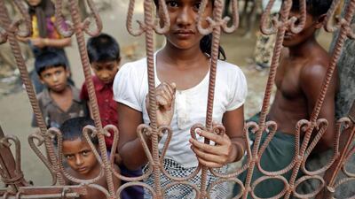 Rohingya Muslims look through the gates of a house in a Myanmar village where many displaced by violence found shelter. ( Damir Sagolj / Reuters)