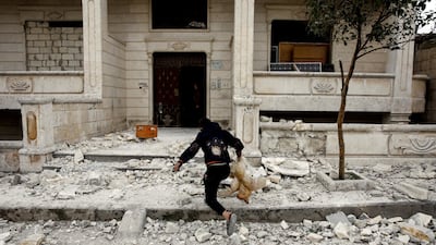 A Syrian boy removes a dead chicken from the debris of a building hit by an air strike in Idlib, Syria. REUTERS