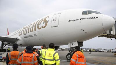Workers watch as flight EK237 of Emirates Airline parks Logan International Airport in Boston. AP Photo / The Boston Globe / Jessica Rinaldi