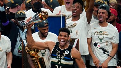 Milwaukee Bucks forward Giannis Antetokounmpo holds with the championship trophy after defeating the Phoenix Suns.