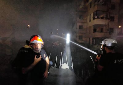 Emergency workers at the scene of an Israeli air strike on the southern suburbs of Beirut. AFP