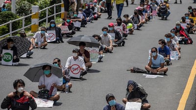 Demonstrators sit on the ground with placards during a coronavirus protest in Kathmandu, Nepal. EPA