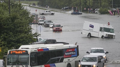 Cars are flooded as people walk though the flooded street of Little York on September 19, 2019 in Houston, Texas. AFP