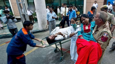 An Indian policeman carries a wounded blast victim at the RML Hospital in New Delhi on September 7, 2011, following a bomb blast at the Delhi High Court. A bomb blast ripped through a crowded reception area at the entrance to New Delhi's High Court in the morning, killing at least nine people and injuring up to 40, police said. Police said the bomb had apparently been placed in a suitcase near the reception where scores of petitioners were queuing for their entry passes to the court complex, situated in the centre of the Indian capital. AFP PHOTO/ MANAN VATSYAYANA *** Local Caption *** 770109-01-08.jpg