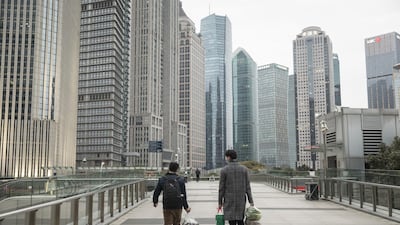 Pedestrians walk through Shanghai's financial district on the first day of work February 10. As some Chinese-based factories have reopened, a degree of normalcy may be slowly returning. Photo: Bloomberg