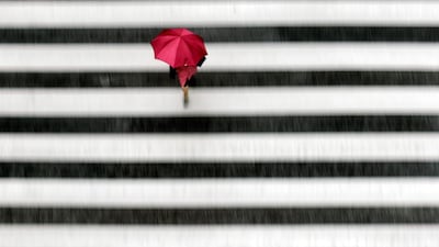 A woman walks a pedestrian crossing in the rain in Tokyo. AP Photo