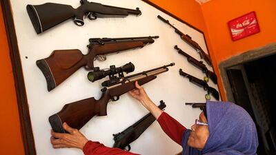 A shopkeeper in Cipacing, Indonesia, takes down her most expensive air rifle, which was manufactured by one of the dozens of air-rifle gunsmiths the village is famous for. Ed Wray / Getty Images