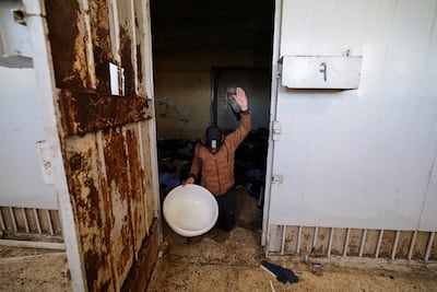 A former inmate demonstrates how he was forced to kneel and raise his hands when he was in front of the prison guards during food distribution at Sednaya prison. Reuters