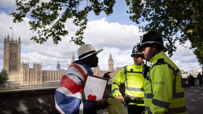 Police officers chat with a member of the public standing in the queue to pay their respects to the late Queen Elizabeth II. AFP
