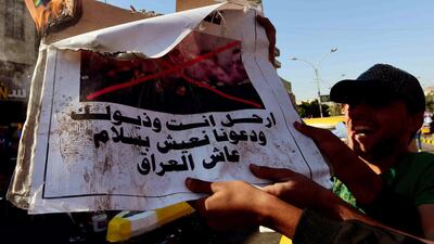 Iraqi protesters burn a portrait of General Qasem Soleimani, who heads the elite Quds Force of Iran's Revolutionary Guard with slogan reading in Arabic 'Leave, with your tails and let us live in peace long live Iraq' during the ongoing protests in Baghdad, Iraq, 18 November 2019. EPA