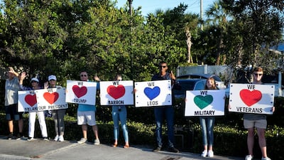 Supporters hold signs as Donald Trump's motorcade heads to his Mar-a-Lago club, in West Palm Beach, Florida, April 18, 2019. Reuters