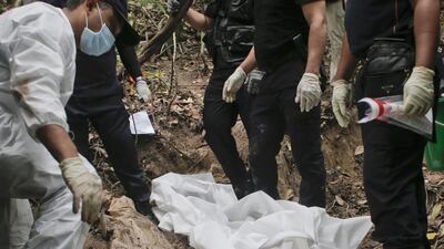 Malaysia's police forensic team exhume human remains from a grave found at Wang Burma hills at Wang Kelian, Perlis, Malaysia, 26 May 2015. Fazry Ismail/ EPA