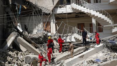 Firefighters remove debris from the site of the collapsed building on Saturday. Reuters