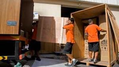 Movers load boxes into a lorry to be shipped overseas by Allied Pickfords. Shipping companies are busier than usual as expatriate families leave Dubai after the end of the school year due to the recession.