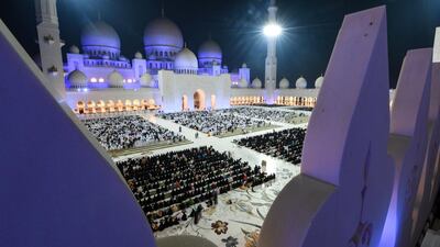 Tens of thousands of worshippers pray at Sheikh Zayed Grand Mosque in Abu Dhabi on Saturday night. The men are dressed mostly in white while the women are dressed in black. Karim Sahib / AFP
