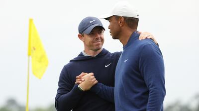 Rory McIlroy and Tiger Woods shake hands on the 18th green during a practice round prior to the 2023 Masters Tournament at Augusta National Golf Club in Augusta, Georgia. AFP