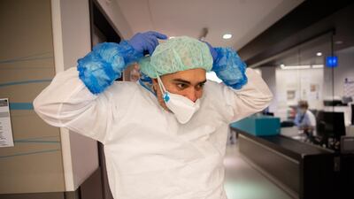 A nurse prepares to enter a Covid-19 room. The unit is understaffed, with what staff they do have now exhausted from the long hours and stressful work. Getty Images