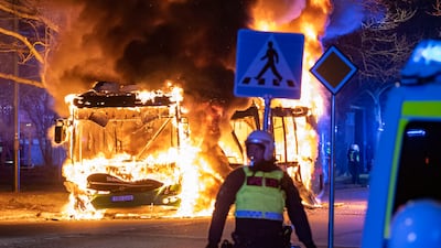 Riot police watch a city bus burn on a street in Malmo, Sweden, after a rally by an anti-Islam far-right group. AP