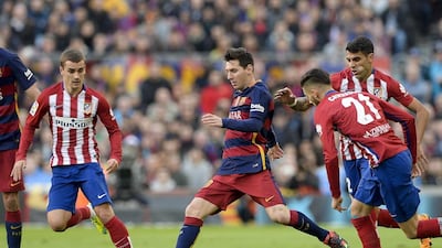 Barcelona's Lionel Messi, centre, vies with Atletico Madrid's Antoine Griezmann, left, and Augusto Fernandez, right, during their La Liga match at the Camp Nou stadium in Barcelona on January 30, 2016. AFP PHOTO/ JOSEP LAGO