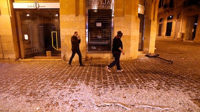 Men pass in front of a coffee shop that was smashed by anti-government protesters. AP Photo