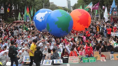 Environmental activists carry earth balloons during a rally demanding action in halting the climate crisis in Seoul, South Korea, on Saturday, September 21, 2019. AP