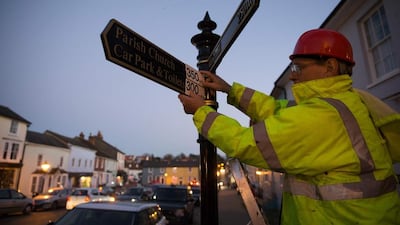 Tony Bennett, secretary of the Active Resistance to Metrication (Arm) activist group, changes a metric measurement on a signpost to an imperial measurement in Thaxted, south-east England on November 28, 2016. Daniel Leal-Olivas/AFP